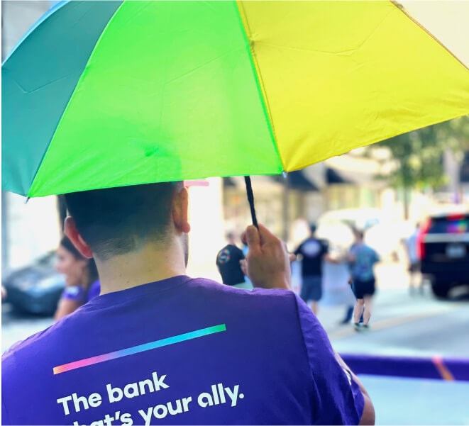 A Pride participant carries a rainbow umbrella in the parade.