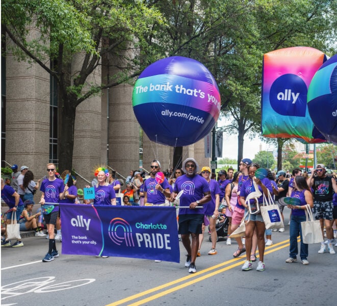 The Ally Charlotte Pride participants carry a banner and balloons in the parade.