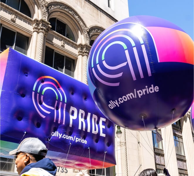 Purple Ally Pride balloons floating through the streets.