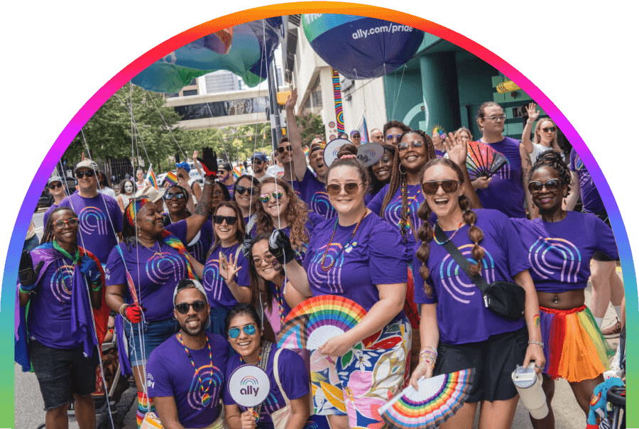 A group of smiling people wearing Ally shirts celebrate together at Pride.