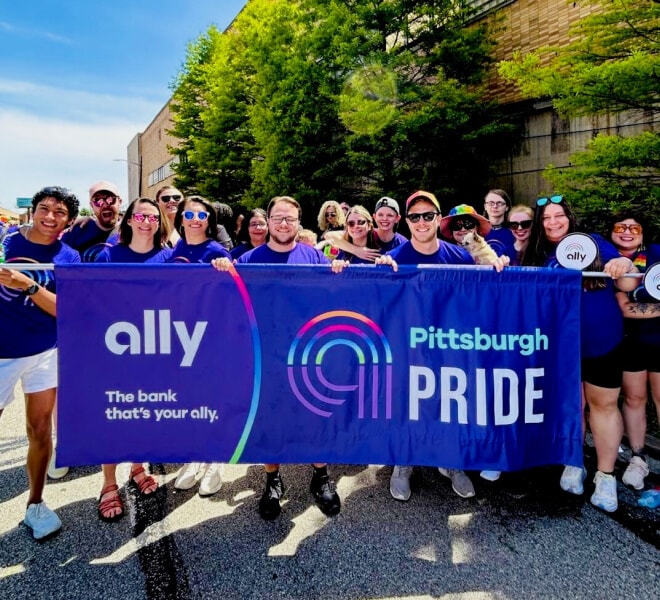 Excited Ally Pride participants pose with the Ally Pittsburgh Pride banner.