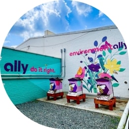 In the lobby of Ally’s Charlotte headquarters, three employees walk in front of a floor-to-ceiling LED wall illuminated with swirling shades of purple.