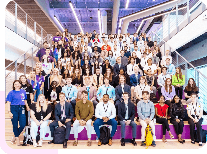 a group photo of smiling Ally interns and early talent sitting on the steps at the Charlotte Center