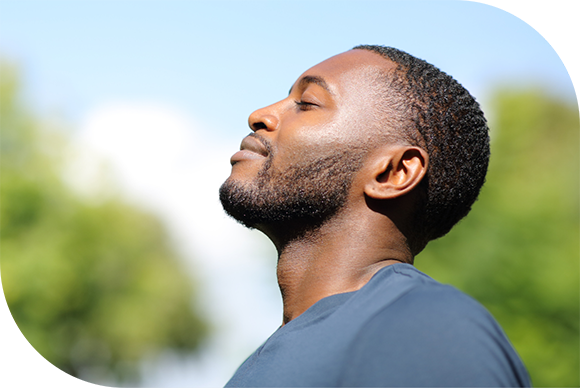 A young black male with eyes closed taking a deep breath