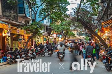 Bustling street in Hanoi, Vietnam, lined with vendors and motorcycles.