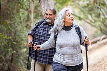 Older couple hiking together through the woods.