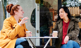 Two women chat at a coffee shop